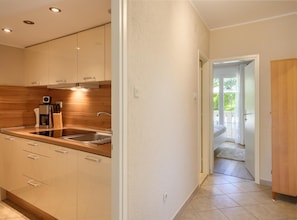 A modern kitchen with a built-in oven, a coffee maker, and a sink. - Apartment in Porec Near Spadici Beach (Porec)