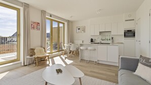 Un apartamento moderno con balcón, cocina y sala de estar.