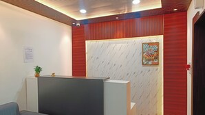 A reception area with a modern design, including a reception desk, seating area, and decorative elements. - Hotel Assi Retreat (Varanasi)