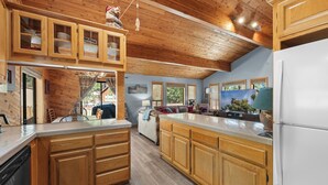 A kitchen with wooden cabinets, a dishwasher, and a refrigerator. - Lakeview Haven- Luxury Retreat (Big Bear Lake)