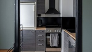 Een moderne keuken met een fornuis, oven en een zwarte afzuigkap.