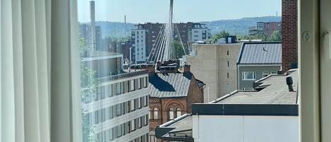 Una ventana con vista a un paisaje urbano, incluyendo un puente y varios edificios.
