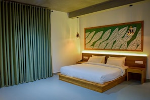 A hotel room with a large bed, a nightstand, a wall-mounted light fixture, and a curtain. - Mistara Ella (ella)