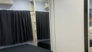 Un dormitorio con una cama, una puerta corredera y un equipo de aire acondicionado.