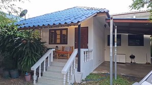 A house with a tiled roof, a porch with a bench, and a staircase leading to the entrance. - House for rants very goo (Rawai)