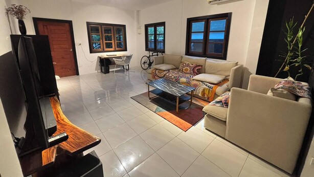 A living room with a sofa, coffee table, TV, and a ceiling fan. - House for rants very goo (Rawai)
