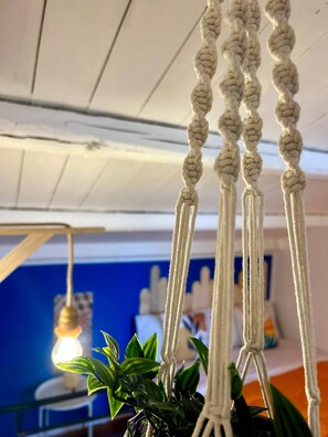 Decoración colgante de macramé con una planta en la parte inferior.