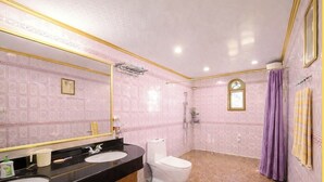 A bathroom with a vanity, toilet, and shower.