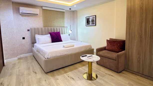 Un dormitorio moderno con cama, mesita de noche y armario.