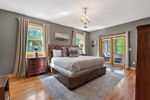 Ein Schlafzimmer mit einem großen Bett, einem Holzschrank und einer Kandelaberleuchte.