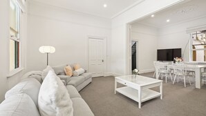 Ett modernt vardagsrum med en soffa, ett soffbord och en matplats.