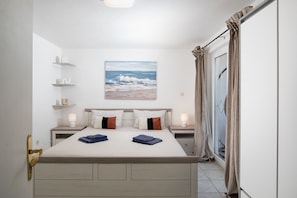 A bedroom with a bed, bedside tables, a painting, and a view through a window. - Croatia/Istria🇭🇷🌊🏖️☀️ villa-liznjan a villa 2 apartments (Ližnjan)