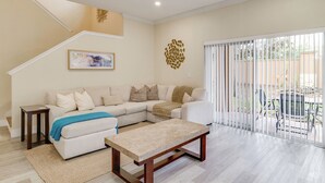 A living room with a sectional sofa, a coffee table, a staircase, and a balcony with a view. - Disney Magic & Resort Fun! Family Gem in Davenport (Davenport)