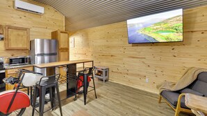 Una cucina moderna con una grande TV, pareti in legno e un'accogliente area salotto.