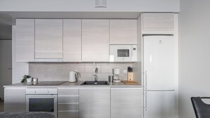 Une cuisine moderne équipée d’un four à micro-ondes, d’un four et d’un réfrigérateur encastrés.