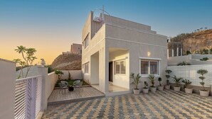 Un bâtiment moderne doté d’une cour intérieure, de plantes en pot et d’un sol à motifs.