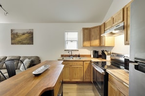 A modern kitchen with wooden cabinets, a stainless steel stove, and a built-in oven.