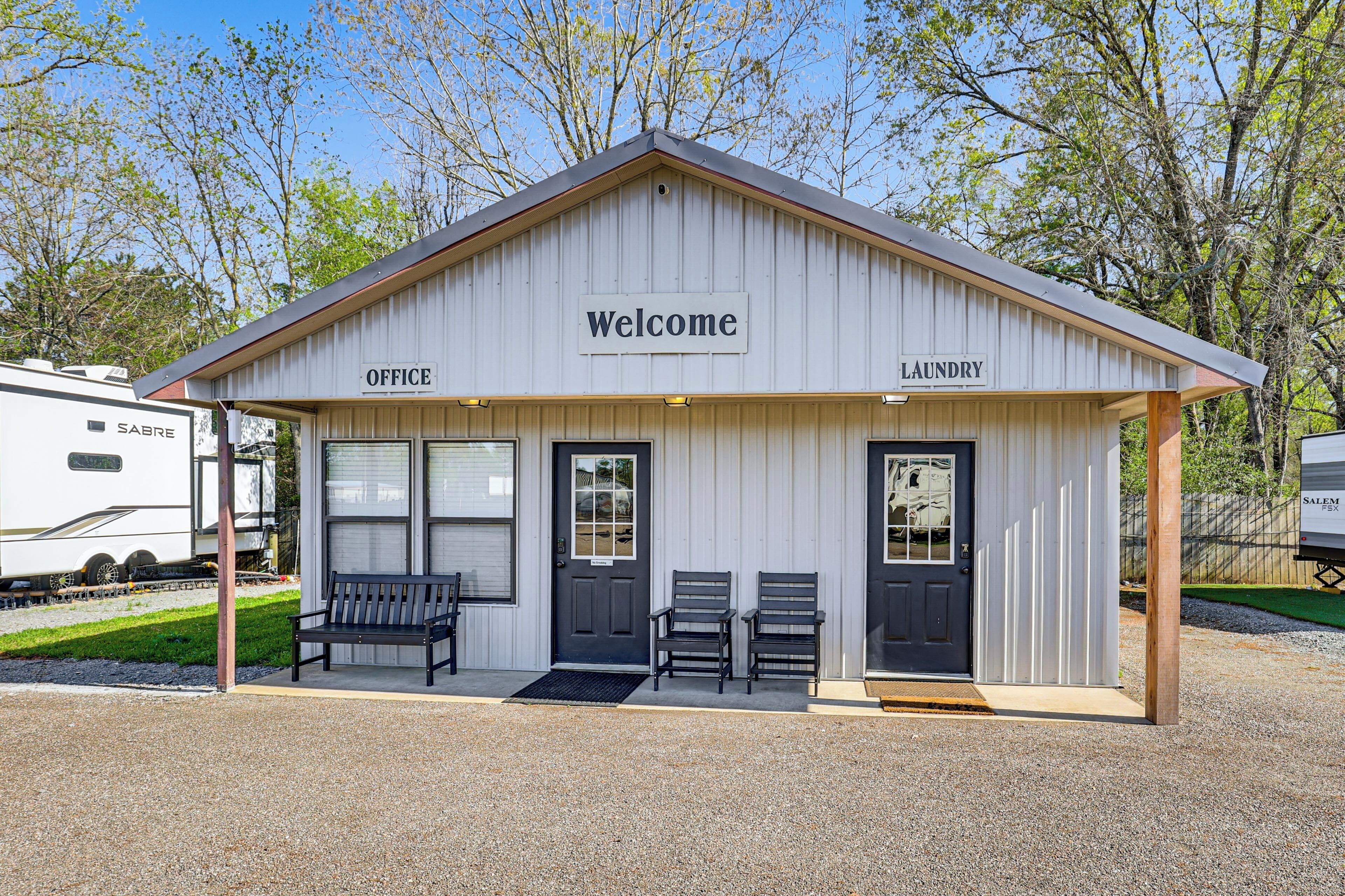 A small building with a 'Welcome' sign, an office, and a laundry area.