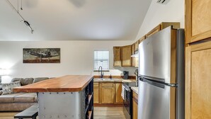 A modern kitchen with wooden cabinets, a stainless steel refrigerator, and a wooden island. - 3 Mi to Sabine River! Modern Cabin Retreat (Joaquin)