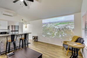 A modern kitchen with a bar area, a large projection screen, and a seating area with a view. - Fish, Explore & Unwind: Couple's Cabin in Joaquin (Joaquin)