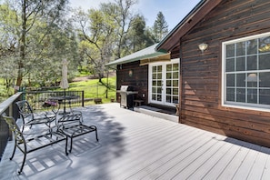 A wooden deck with outdoor furniture, a grill, and a patio table. - Swim & Golf! 'Jackson Mill Cottage' in Groveland (Groveland)
