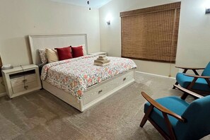 A bedroom with a bed, a nightstand, a chair, and a window with blinds. - Swim & Golf! 'Jackson Mill Cottage' in Groveland (Groveland)