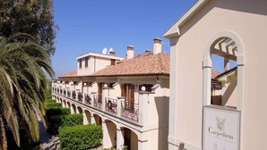 Un hôtel doté d’une galerie couverte, d’arcades et d’une enseigne indiquant « Résidence Carpediem relais ».