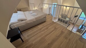 Une chambre à coucher avec un lit, un bureau et une vue sur l’extérieur.