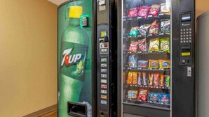Ein 7UP-Getränkeautomat und ein Snackautomaten mit verschiedenen Snacks.