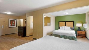 Een hotelkamer met een bed, een kaptafel, een spiegel en een groene accentmuur.