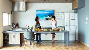 Une cuisine moderne dotée d’un grand îlot central, d’un four encastré et d’un réfrigérateur en acier inoxydable.