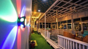 An indoor area with a balcony, artificial grass, and a railing. - The Golden View Farm & Resort (Sonkach)