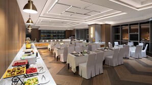 A hotel dining area with multiple tables, chairs, and a buffet line. - Guizhou Fengrun Karst Hotel (Guiyang)