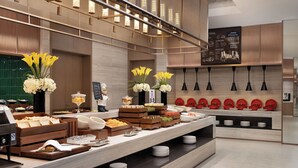 Un buffet moderne avec une variété de plats, un coin café et un menu écrit à la craie.