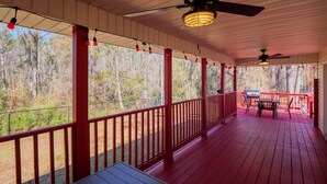 A covered porch with red railings, a ceiling fan, and a table with chairs. - Southern Pines Hideaway – Peaceful Hahira Stay (Hahira)