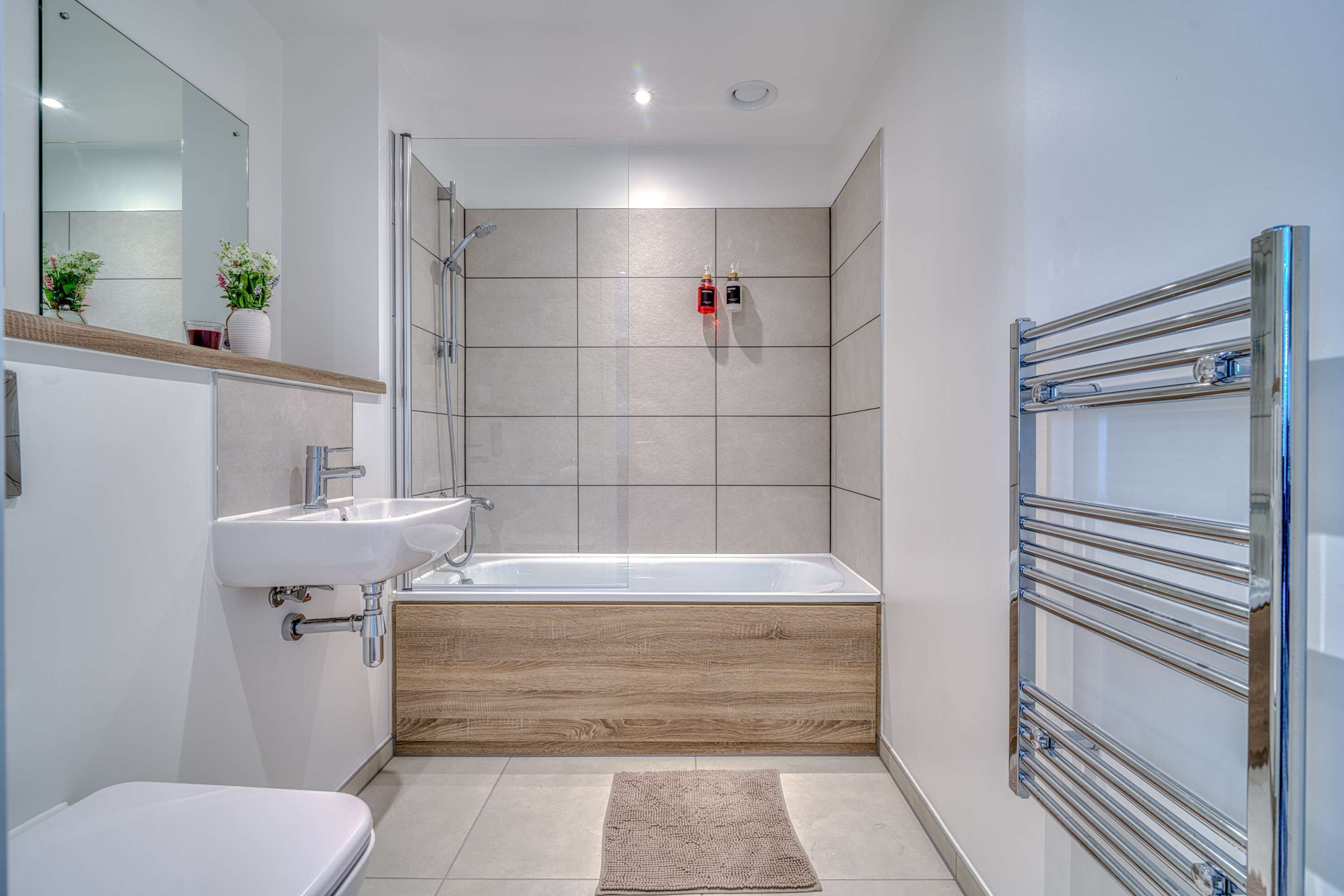 Et moderne badeværelse med badekar, vask og toilet.