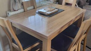 A wooden dining table with chairs, a basket, and a welcome sign on the wall. - Weymouth Bay Holiday Park - Holiday Accommodation 15694 (Weymouth)