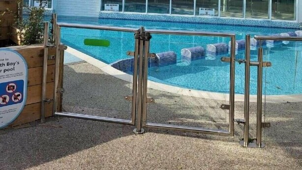 A swimming pool with a glass enclosure, a wooden fence, and a sign indicating no diving. - Weymouth Bay Holiday Park - Holiday Accommodation 15694 (Weymouth)