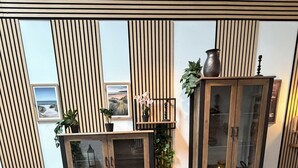 A room with two dark armchairs, a glass coffee table, a wooden cabinet, and a patterned rug. - Wohnglück Alte Werft Leer (Leer (Ostfriesland))