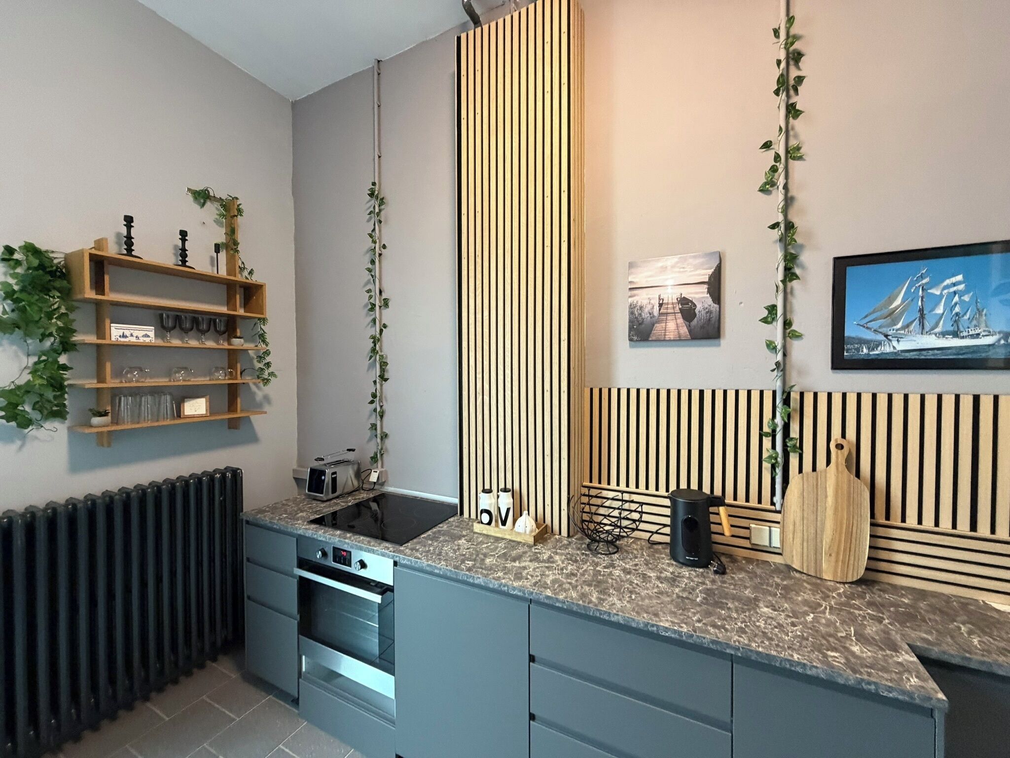 Eine moderne Küche mit eingebautem Ofen, Spüle und Arbeitsplatte mit Schneidebrett und Messer.