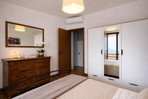 A bedroom with a bed, a dresser, a mirror, and a wardrobe. - Appartamento Angela by Theater Home - with marvellous lake view (Tignale)