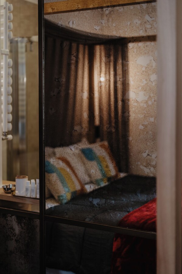 A room with a bed, a mirror, and a wall with peeling paint. - Hotel Centrale (Mezzocorona)