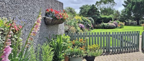 Een tuin met plantenpotten en een stenen muur.