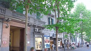 Una strada fiancheggiata da edifici, alberi e persone.