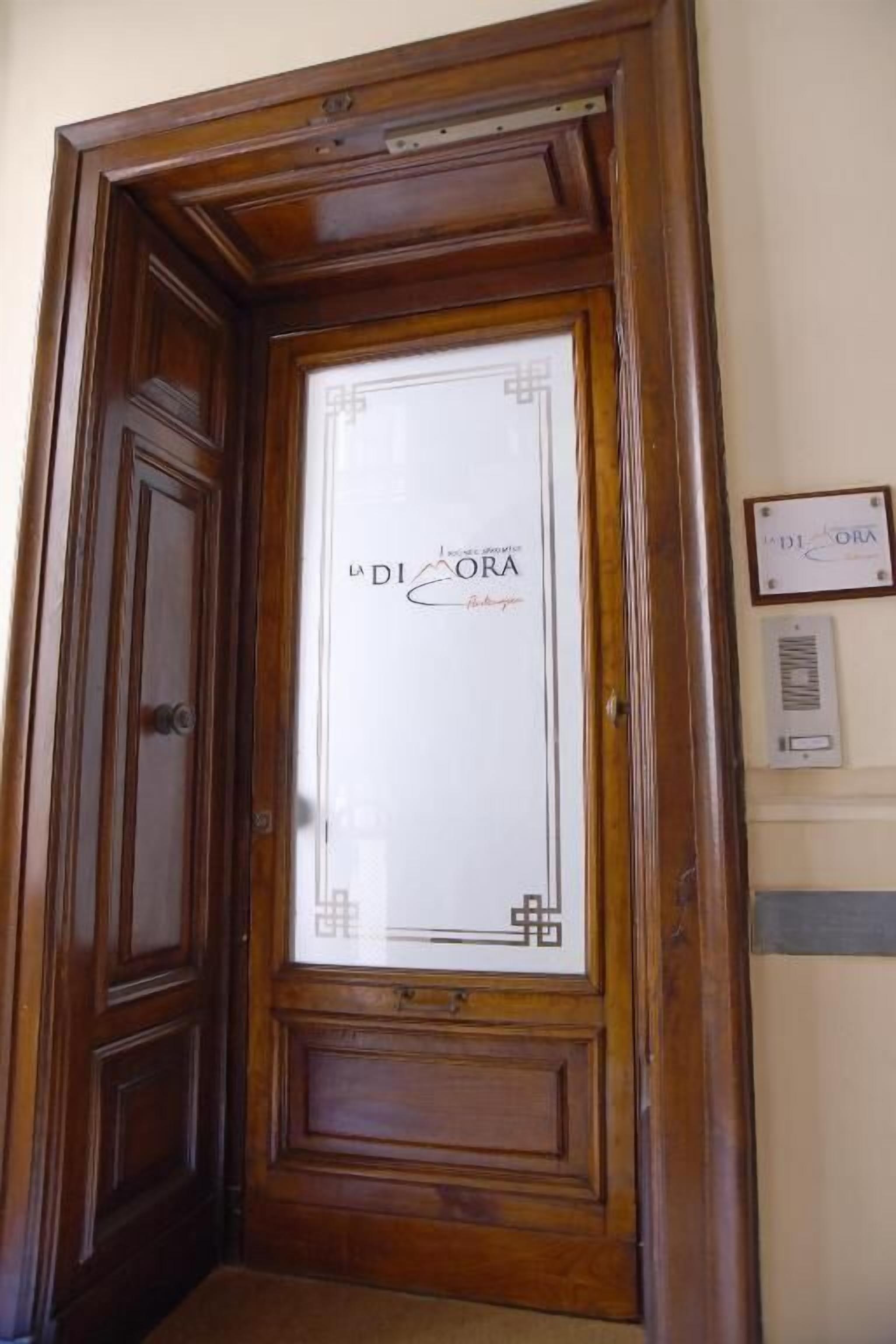 A wooden door with a glass panel displaying 'La Diadora' branding.