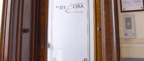 A wooden door with a glass panel displaying 'La Diadora' branding.