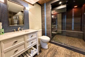 A modern bathroom with a large mirror, white vanity, and a glass-enclosed shower. - Teton Ranch Home w/Large Family Room + Fireplace (Driggs)