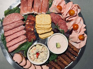 Eine Platte mit verschiedenen Fleischsorten, Käsesorten und Dips.