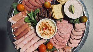 A platter with various meats, cheese, and a dipping sauce. - Chateau D'Amour Luxury Boutique (Bucharest)