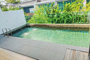 Une piscine dotée d’une terrasse carrelée et d’un espace de terrasse en bois.